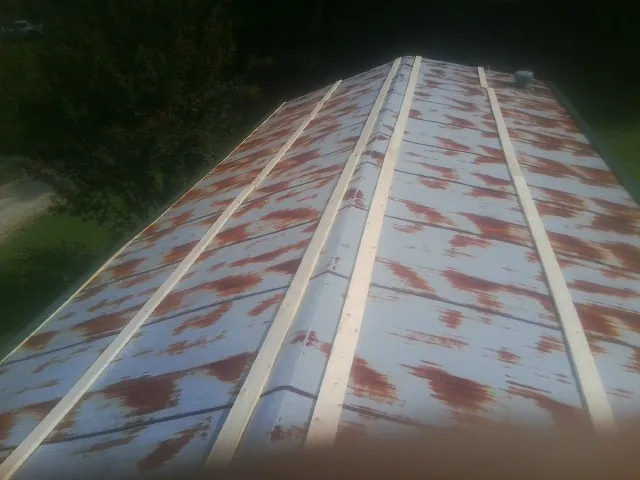 Rusted metal roof panels with new wood purlins before replacement — Storm Damage Roof Repair in Kerkhoven by Roofing Brothers